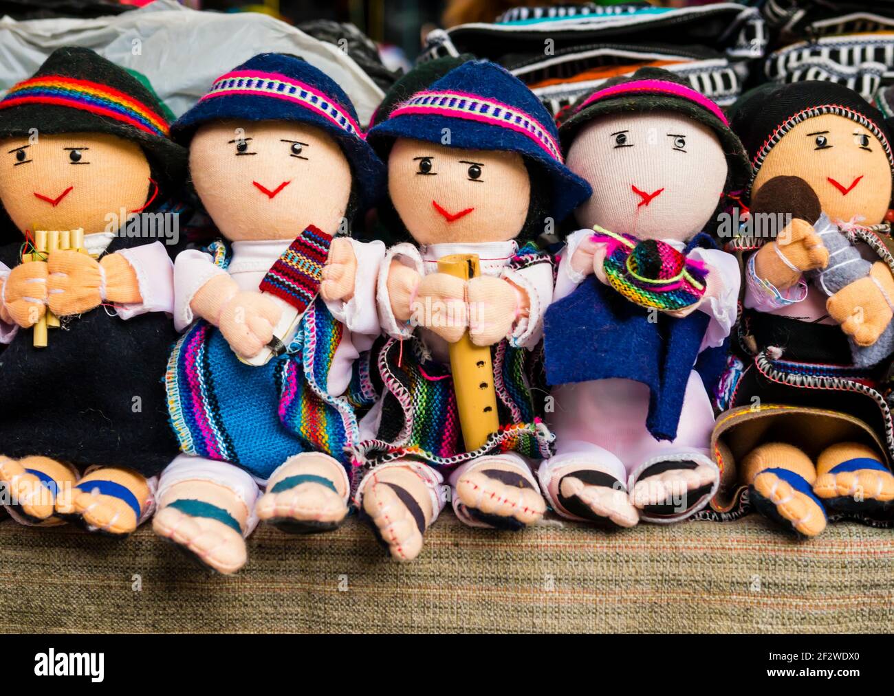 Atemberaubende Reihe von männlichen Stoffpuppen in traditioneller Kleidung, die Musikinstrumente spielen, Otavalo Markt, Ecuador Stockfoto