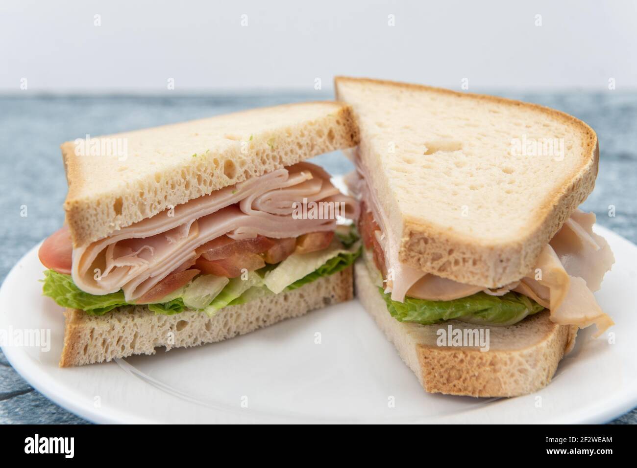 Dickes, geschichtetes putenbrot mit geschnittenem Fleisch und gehacktem Gemüse. Stockfoto