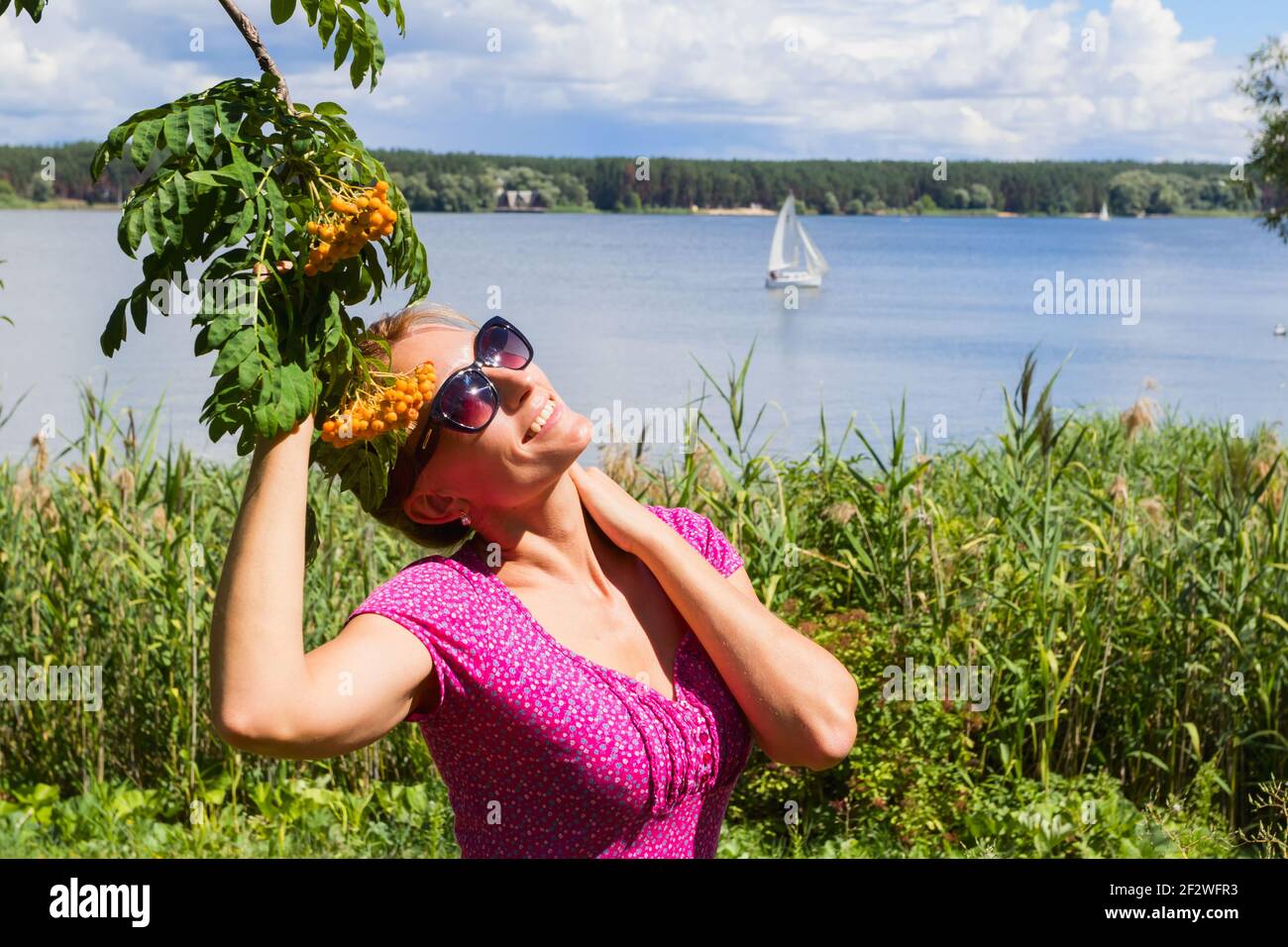 Eine Frau in der Nähe des Sees genießt sonniges Licht. Stockfoto