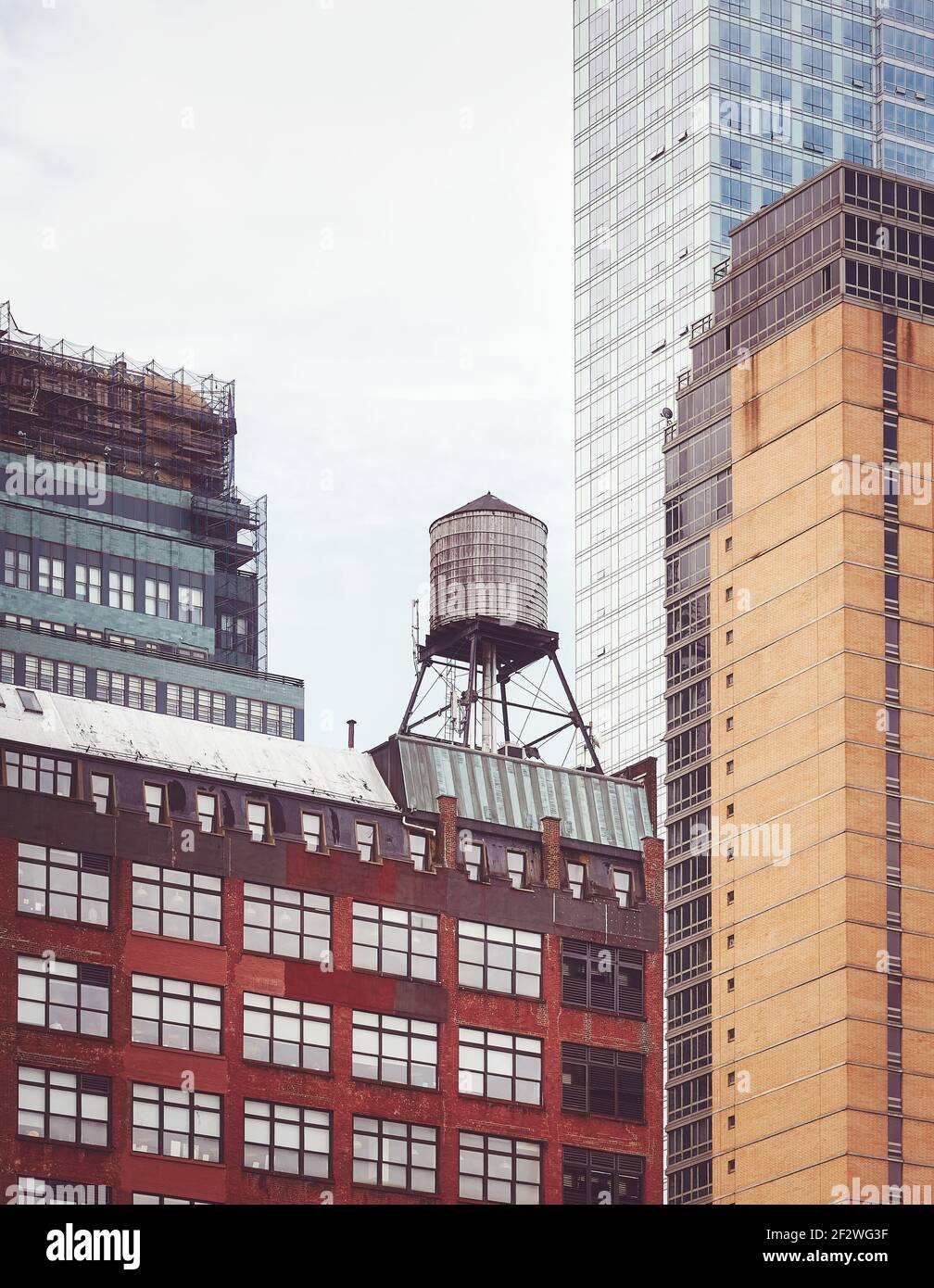 Alter Wasserturm, eines der New York City Symbole, unter modernen Gebäuden, Farbtonierung angewendet, USA. Stockfoto