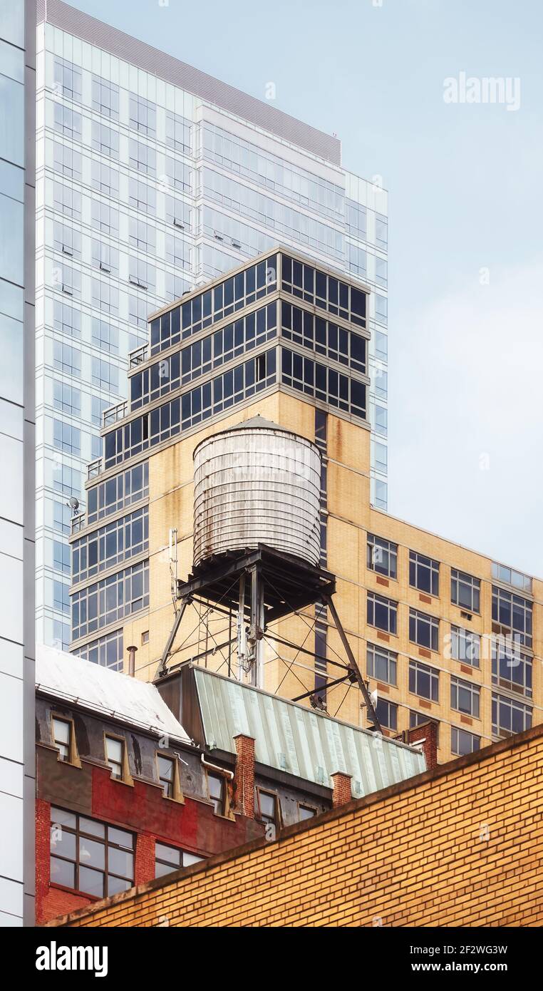 Alter Wasserturm zwischen modernen Gebäuden, New York City, USA. Stockfoto