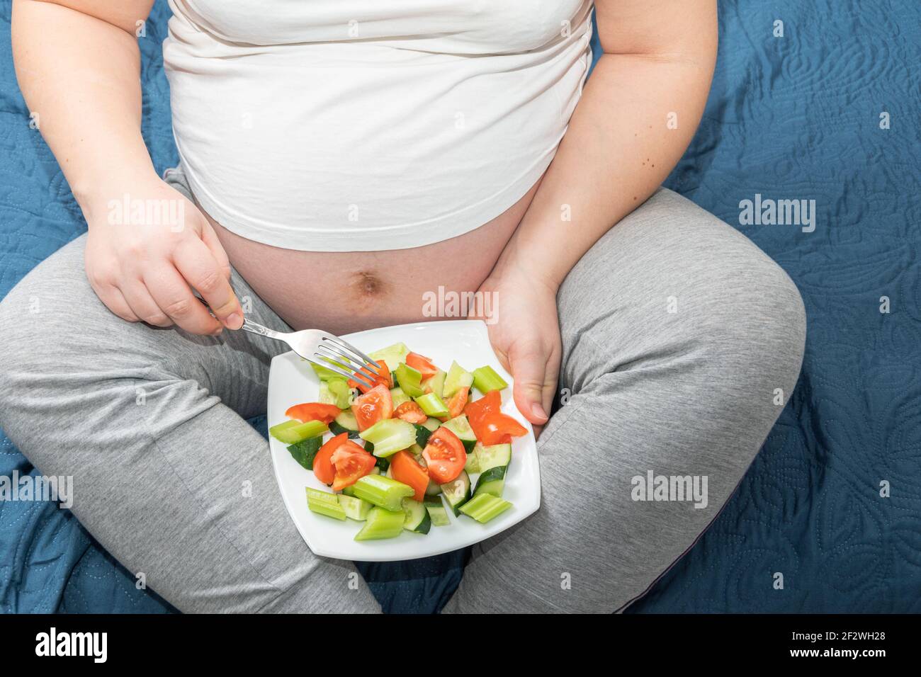 Draufsicht Nahaufnahme einer schwangeren Frau mit einem Gemüse frischen Salat in den Händen. Gesunde Ernährung und Schwangerschaft Konzept Stockfoto