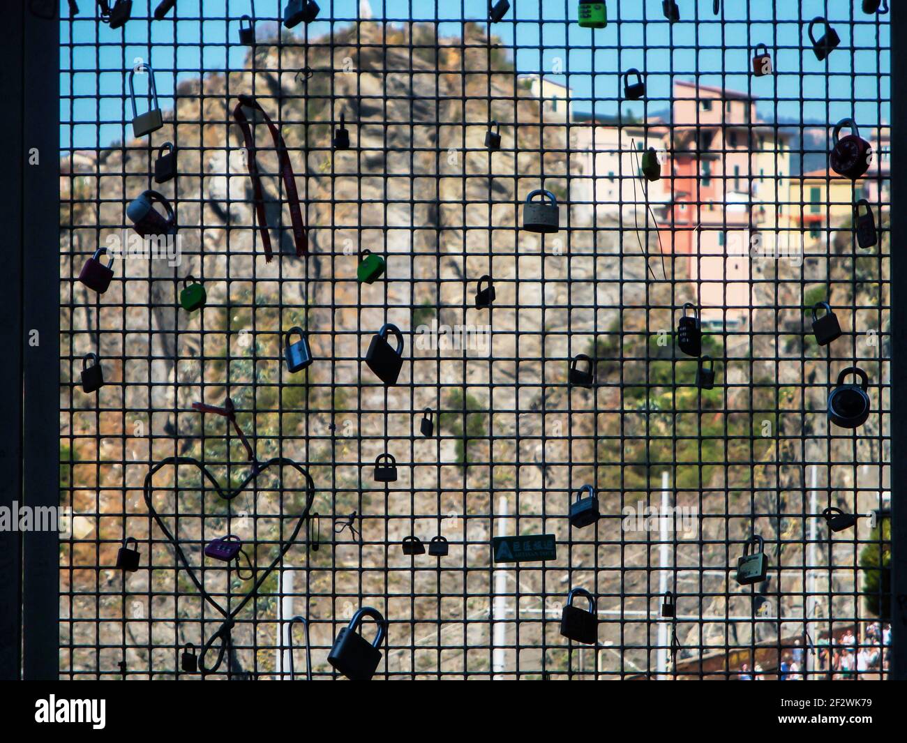 Zaun mit Liebesschlösser. Im Hintergrund sieht man die Häuserzeile in einer Stadt in der Cinque Terre Stockfoto