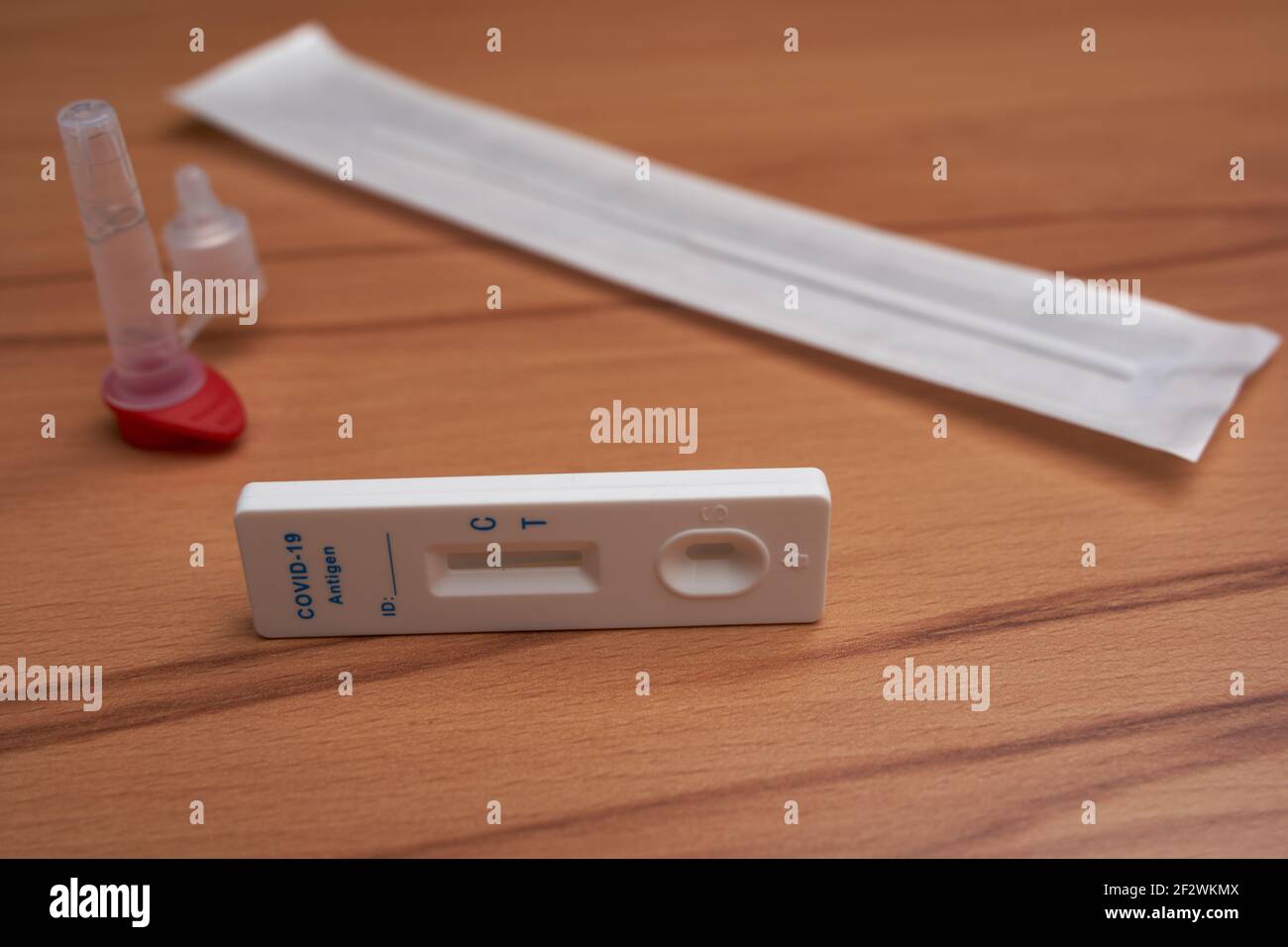 Nurtingen, 08. März 2021: Antigen-Test auch Corona-Schnelltest mit Testkassette, Wattestäbchen und Probenröhrchen auf einer Holzoberfläche. Side Vie Stockfoto