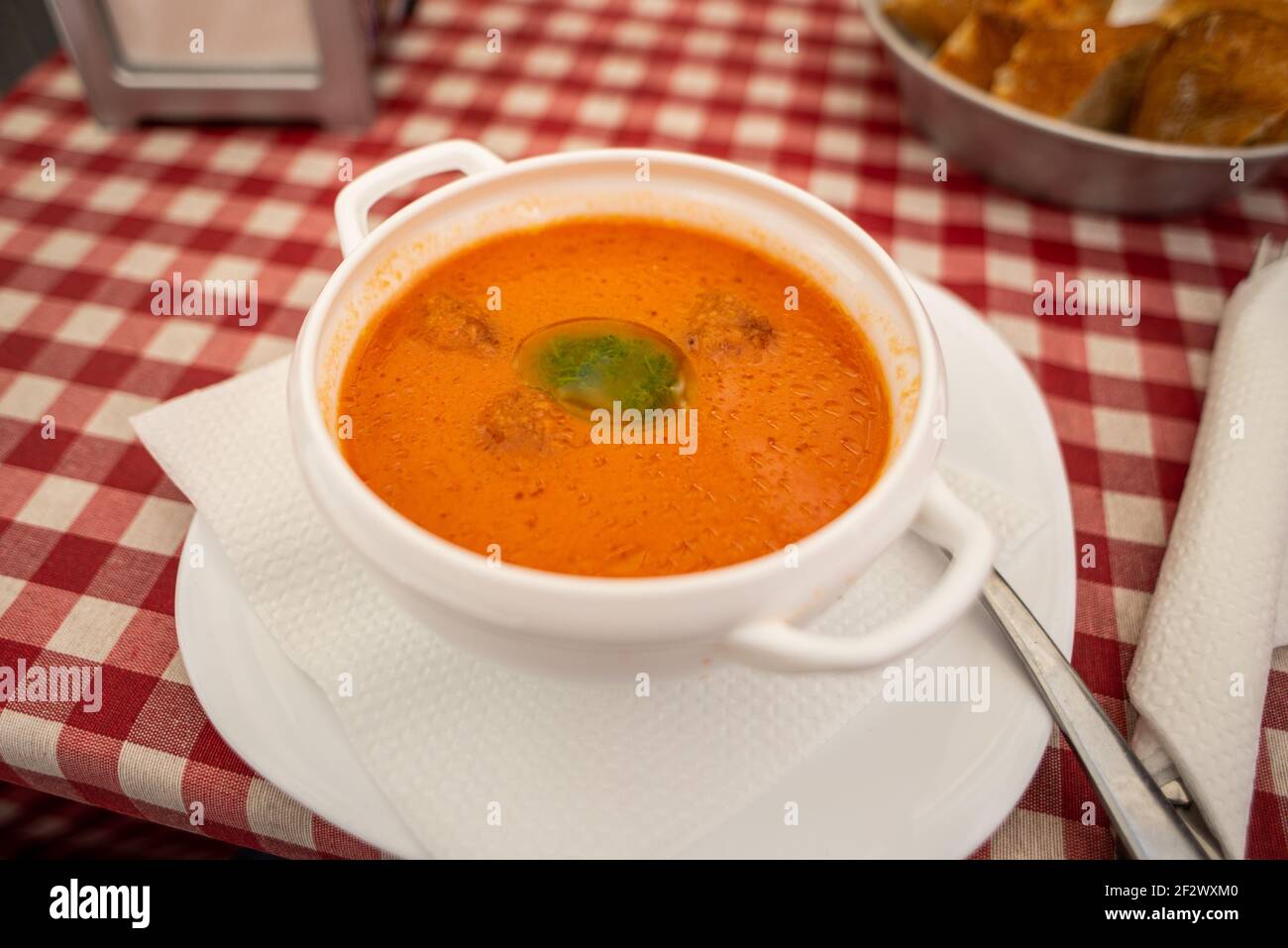 Eine Schüssel Gazpacho auf einem Restauranttisch in Valencia. Gazpacho ist eine frische Tomatensuppe, die als Vorspeise serviert wird Stockfoto