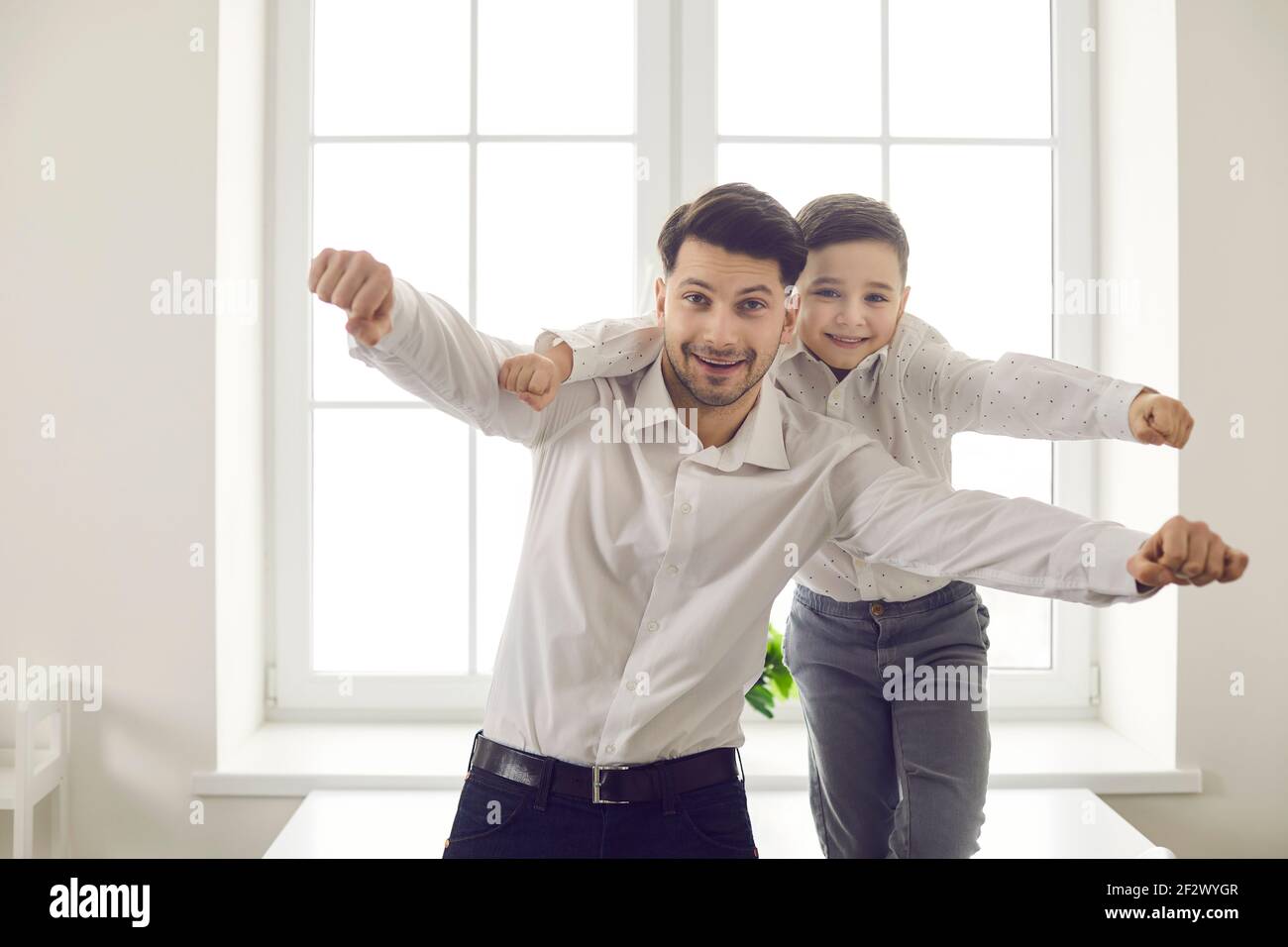 Glückliche Familie von Vater und Sohn Spaß zu Hause machen einen imaginären Flug mit der Kamera. Stockfoto