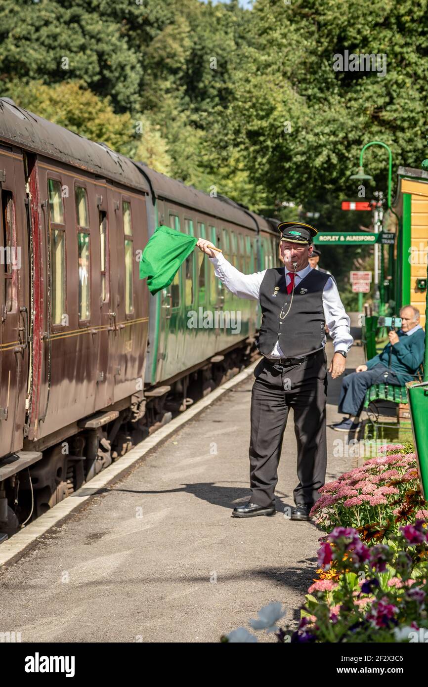 Die Garde schwenkt seine grüne Flagge, Medstead und Four Marks Station, Hampshire Stockfoto