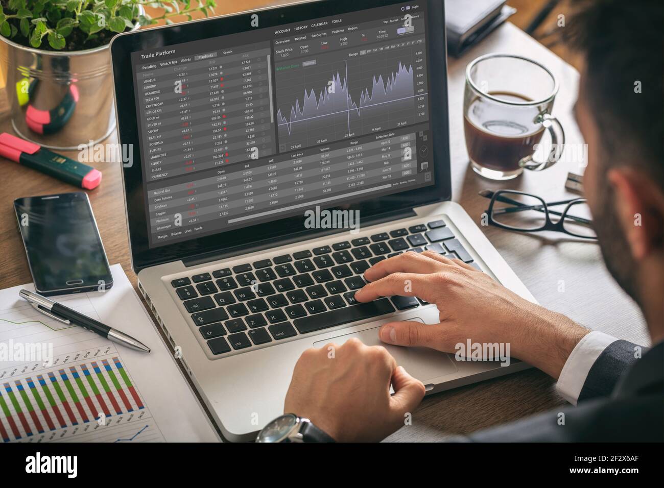 Handelsplattform, Devisenhandel. Börsenmarktanalyse, Mann, der mit einem Laptop arbeitet, Überwachungs-App auf dem Bildschirm, Büroschreibtischhintergrund. Binär opt Stockfoto