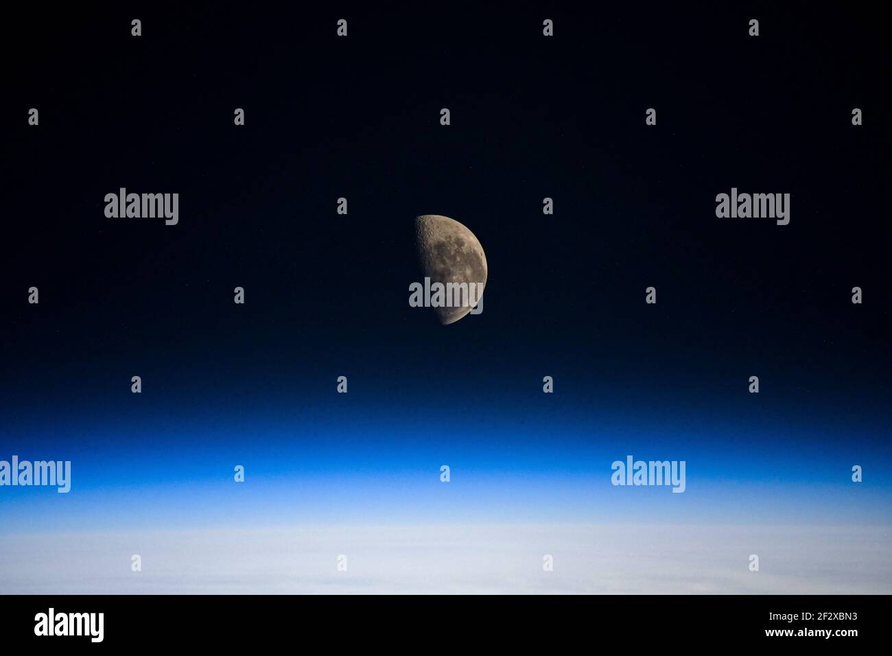 Der Mond des letzten Viertels über dem Erdhorizont, wie er von der Internationalen Raumstation aus gesehen wurde, als er 262 Meilen über dem 5. März 2021 in der Erdumlaufbahn umkreiste. Der Mond des letzten Viertels ist der genaue Punkt des Mondes, der die Sonne auf dem letzten Bogen des Mondprozesses paradiert. Stockfoto