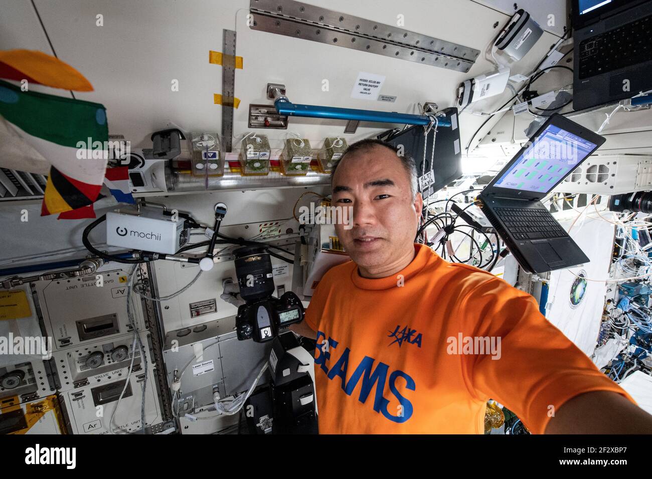 JAXA Astronaut und Expedition 64 Flugingenieur Soichi Noguchi posiert mit Pflanzen, die in Containern für die Asian Herbs Studie an Bord der Internationalen Raumstation wachsen 9. März 2021in Erde Orbit. Die Weltraumbotanik Untersuchung erforscht Möglichkeiten, schnell wachsende Pflanzen für die traditionelle Medizin und Lebensmittelaromen verwendet kultivieren. Stockfoto