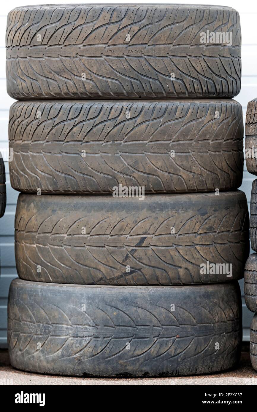 Haufen alter abgenutzter Reifen. Die Reifen sind schmutzig und abgenutzt,  mit sehr wenig Lauffläche. Der Text REIFEN ERSETZEN ist auf den Reifen  sichtbar Stockfotografie - Alamy