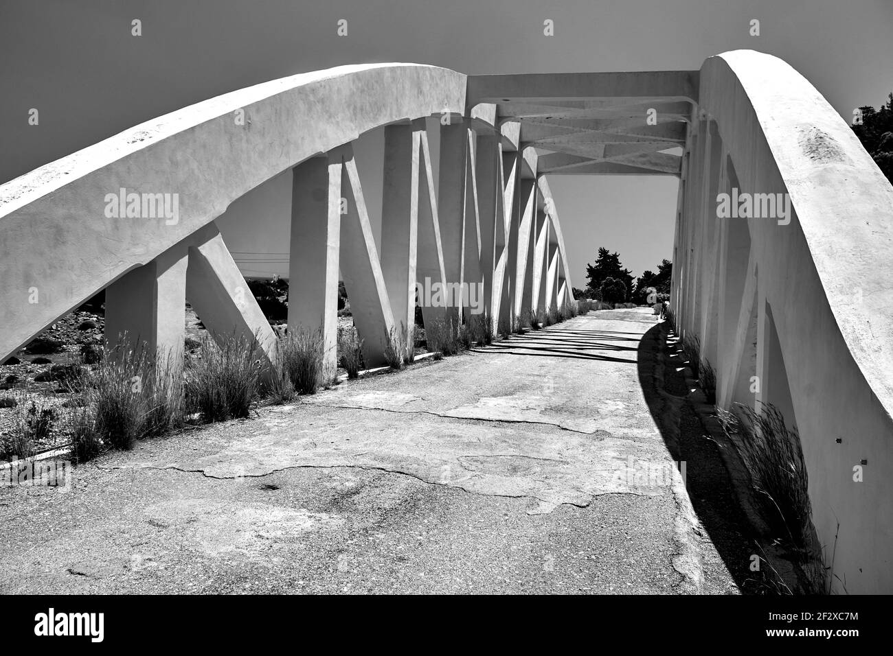 Eine Straße gewölbte Brücke über einen getrockneten Fluss auf der Insel Rhodos, monochrom Stockfoto
