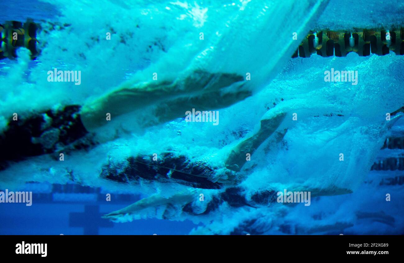 Unterwasseransicht von Schwimmern, die für ein Rennen in einen Pool tauchen. Stockfoto