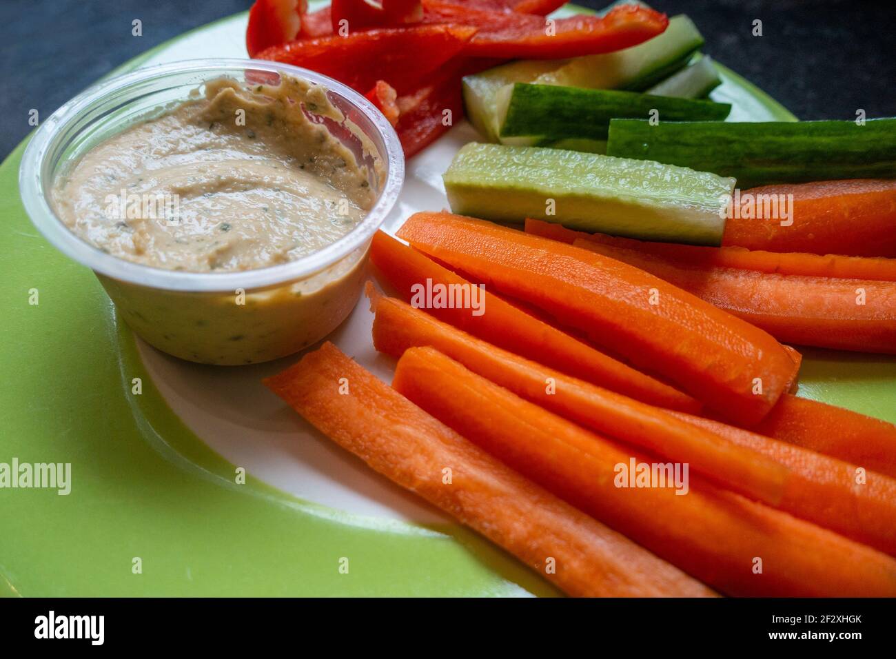 Gesunde Mahlzeit aus geschnittenem, rohem Gemüse mit einem Humusdip Stockfoto