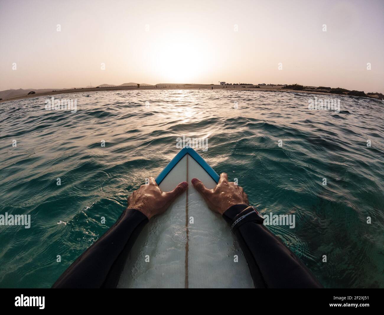 Surfer pov Sonnenuntergang im Wasser sitzend auf seinem Surfbrett - Urlaub, Urlaubskonzept Stockfoto