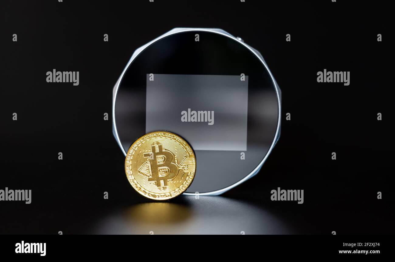 Ein Bitcoin vor einer digitalen Brieftasche. Stockfoto