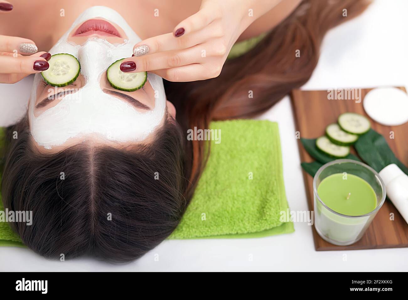 Schöne junge Frau erhalten Gesichtsmaske der Gurke. Stockfoto