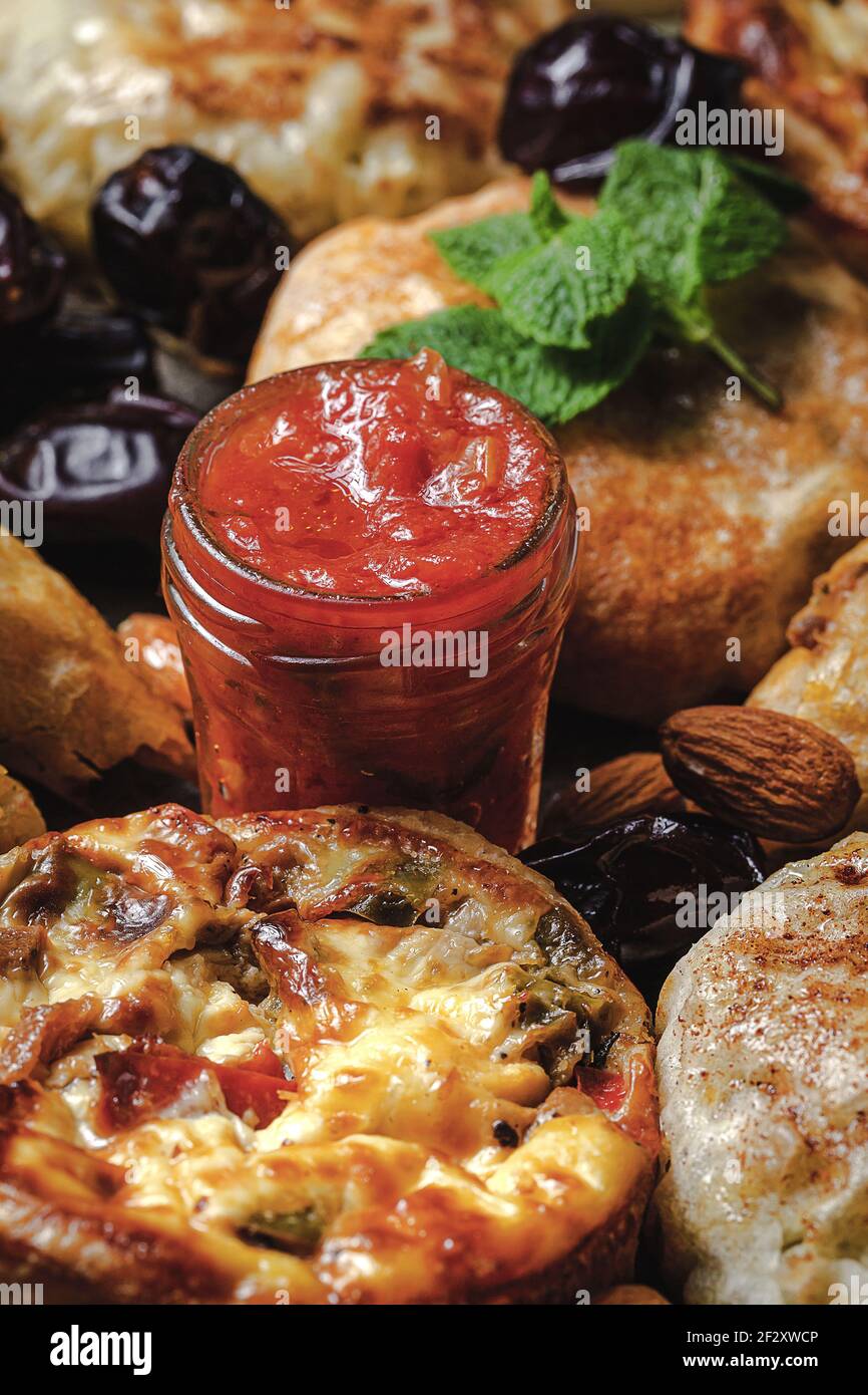 Von oben von leckeren Manakish in der Nähe verschiedene marokkanische Speisen mit Salsa und getrocknete Datteln während Ramzan Ferien Stockfoto