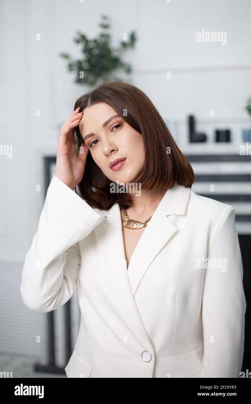 Eine hübsche Frau in einem Büro weiße Jacke in einem Helles Zimmer Stockfoto