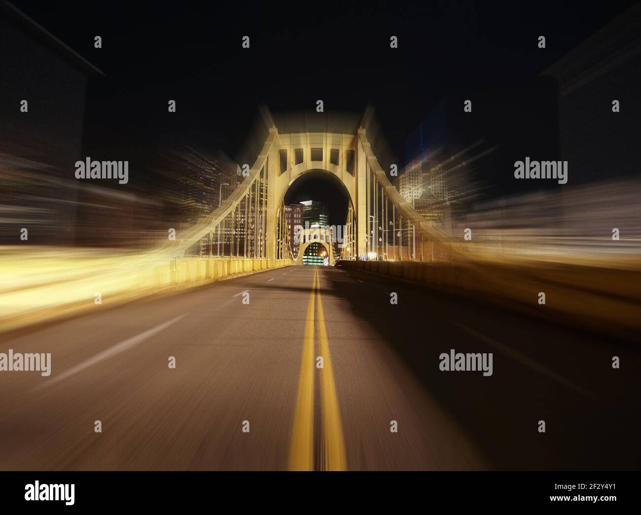 Nachtansicht der gelben Brücke, die zur Innenstadt von Pittsburgh Pennsylvania führt, mit Bewegungsunschärfen. Stockfoto