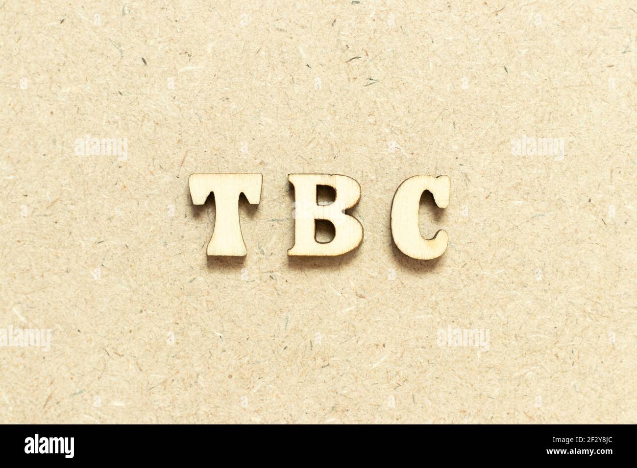 Buchstabe im Wort TBC (Abkürzung von muss bestätigt oder fortgesetzt werden) auf Holzhintergrund Stockfoto