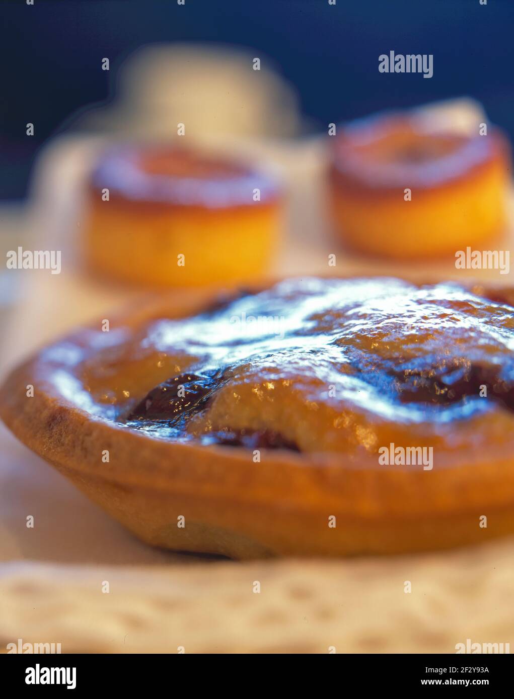 Kuchen und Gebäck im Studio mit Tellern und blau erschossen Hintergrund Stockfoto
