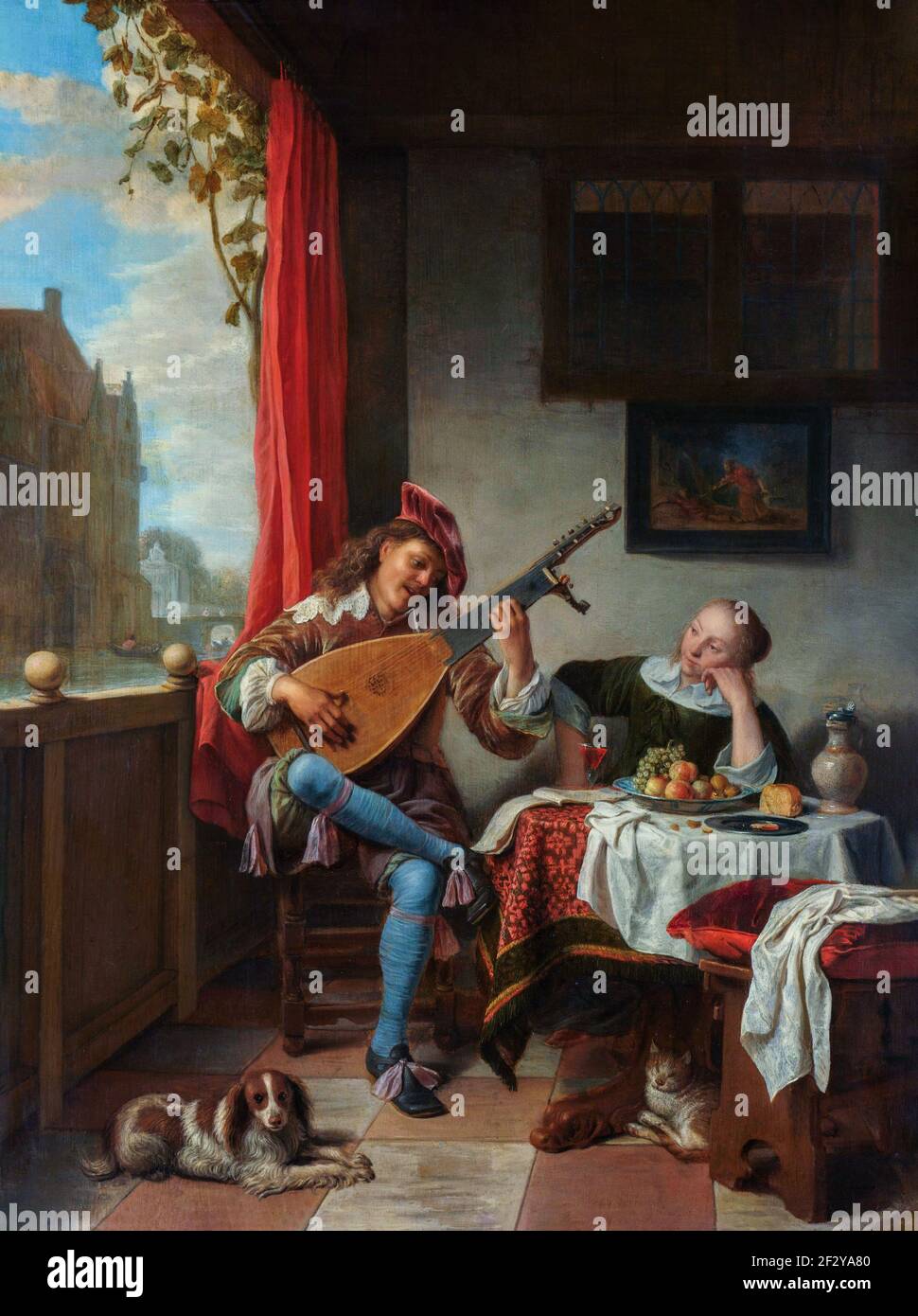 Der Lautenspieler. In einem Raum spielt ein junger Mann für eine Frau Laute, während er an einem Tisch sitzt und zuhört. Auf dem Tisch eine Schale mit Obst, Brot, Stockfoto