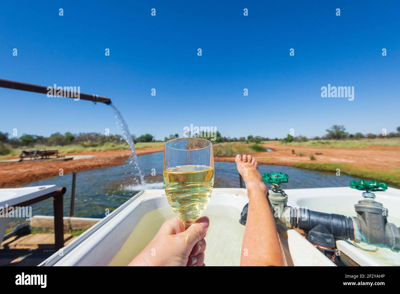 Touristen entspannen bei einem Glas Wein in den Hot Bore Baths in Charlotte Plains, in der Nähe von Cunnamulla, Queensland, QLD, Australien Stockfoto