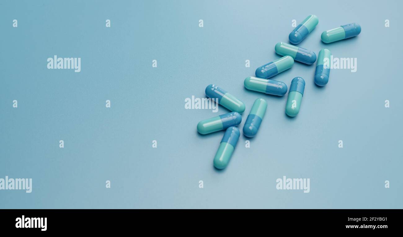 Blaue Kapsel Pillen auf blauem Hintergrund. Online-Apotheke Banner. Gruppe von Kapseln Pillen. Pharmaindustrie. Arzneimittelentwicklung und neue Arzneimittelforschung Stockfoto