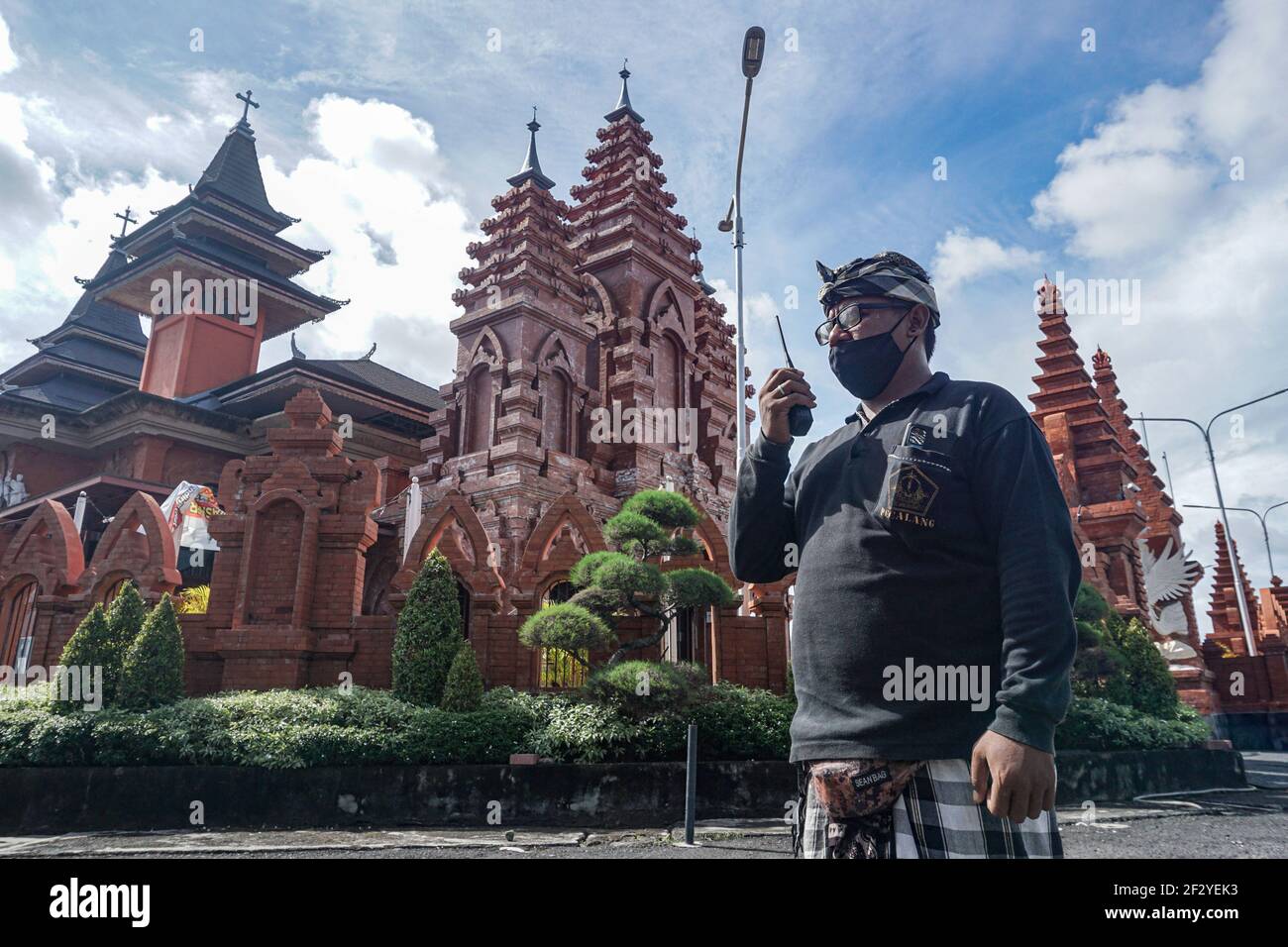 Denpasar, Indonesien. März 2021, 14th. Balinese traditionelle Sicherheit von Pecalang pending durch einen Funkruf in Denpasar Cathedral Church. Bali Island feiert Nyepi, den Tag der Stille. Nyepi ist der hinduistische balinesische Feiertag der Selbstreflexion, in dem alle Aktivitäten gestoppt werden und die Menschen nicht nach draußen kommen dürfen, wenn alle Lichter niedrig gehalten werden, keine Arbeit und keine Freuden. Kredit: SOPA Images Limited/Alamy Live Nachrichten Stockfoto