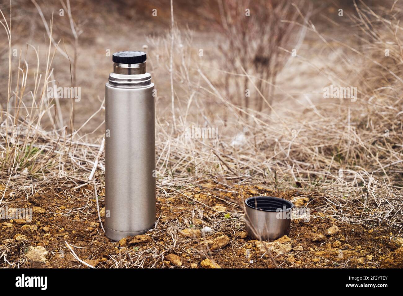 Vakuum-Thermoskannen aus Stahl mit Tee oder Kaffee, im Freien. Wandern, Aktivtourismus, Picknick, Heißgetränk-Konzept Stockfoto