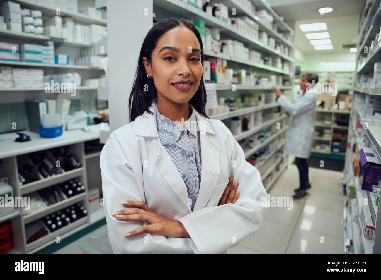 Porträt eines jungen afroamerikanischen Apothekers, der zwischen dem Gang steht Chemiker Stockfoto