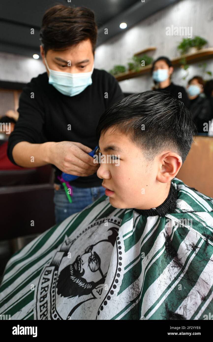 Fuyang, China. März 2021, 14th. Ein Friseur sah Haare schneiden für ein  Kind.Es ist der zweite Tag des zweiten Mondmonats. Es gibt ein chinesisches  Sprichwort: „am zweiten Februar schaut der Drache nach