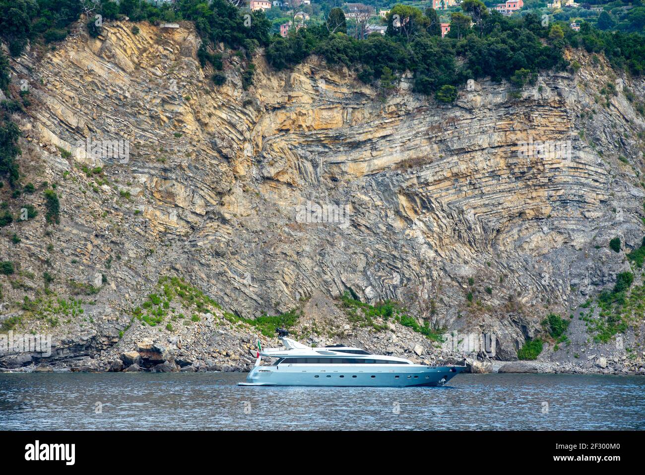 Luxusyacht segelt das Meer vor eigenartigen Kalksteinformationen an der ligurischen Küste in der Nähe der Stadt Camogli, Italien Stockfoto