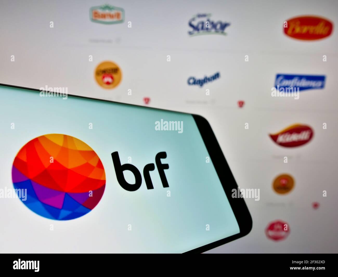 Handy mit Logo der brasilianischen Lebensmittelverarbeitungsfirma BRF SA auf dem Bildschirm vor der Webseite mit Portfolio. Fokus auf Mitte rechts des Telefondisplays. Stockfoto