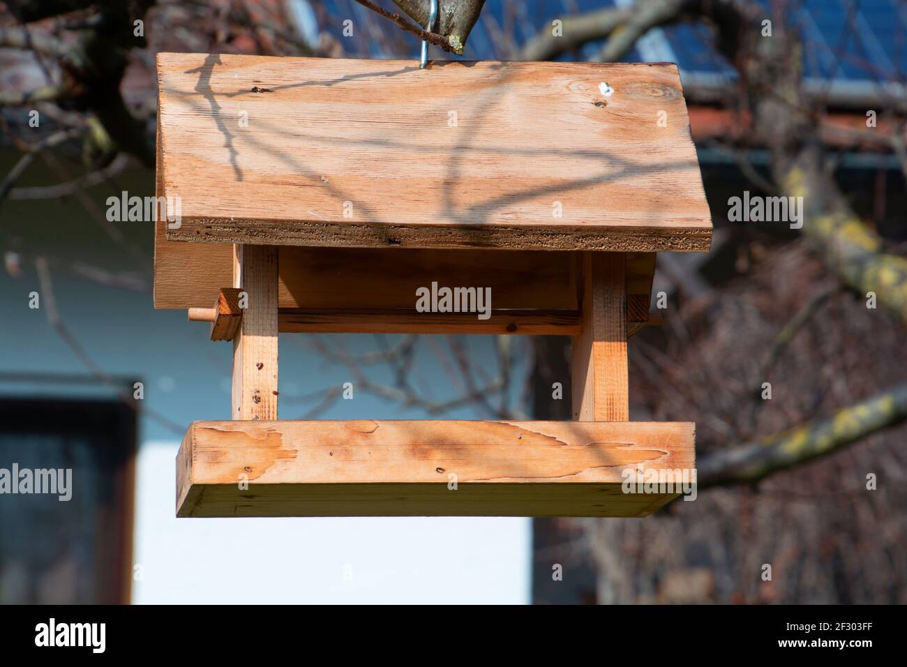 Holzhaus für Vögel, die an einem Apfelbaum hängen Der Ziergarten Stockfoto