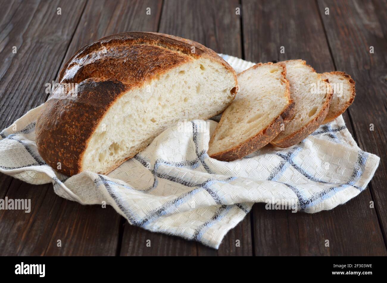 Hausgemachtes Brot in Scheiben mit einer knusprigen Kruste in einer Küche Nahaufnahme des Handtuchs Stockfoto