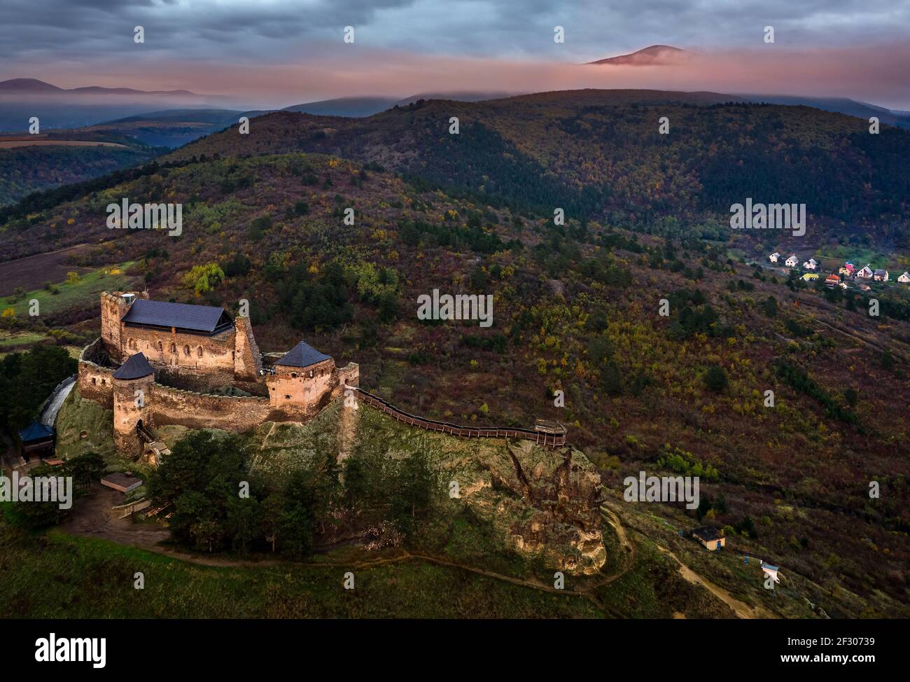 Boldogko, Ungarn - Luftaufnahme des Boldogko Schlosses (Boldogko vara/Boldogkovaralja) in der Herbstsaison mit Zemplen Berge glühen im Hintergrund ein Stockfoto