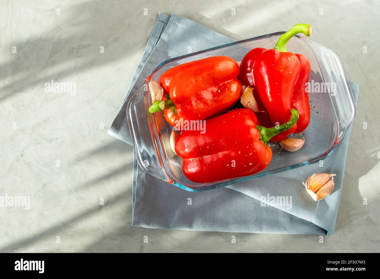 Nahaufnahme von reifen roten Paprikaschoten auf einem zum Backen vorbereiteten Glasblech. Gesunde Ernährung Konzept. Selektiver Fokus. Stockfoto