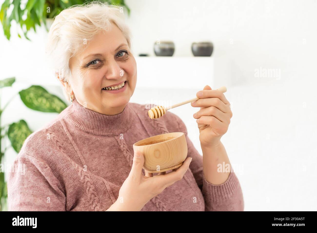 Ältere Frau Honig zu Hause, Lifestyle-Konzept Stockfoto