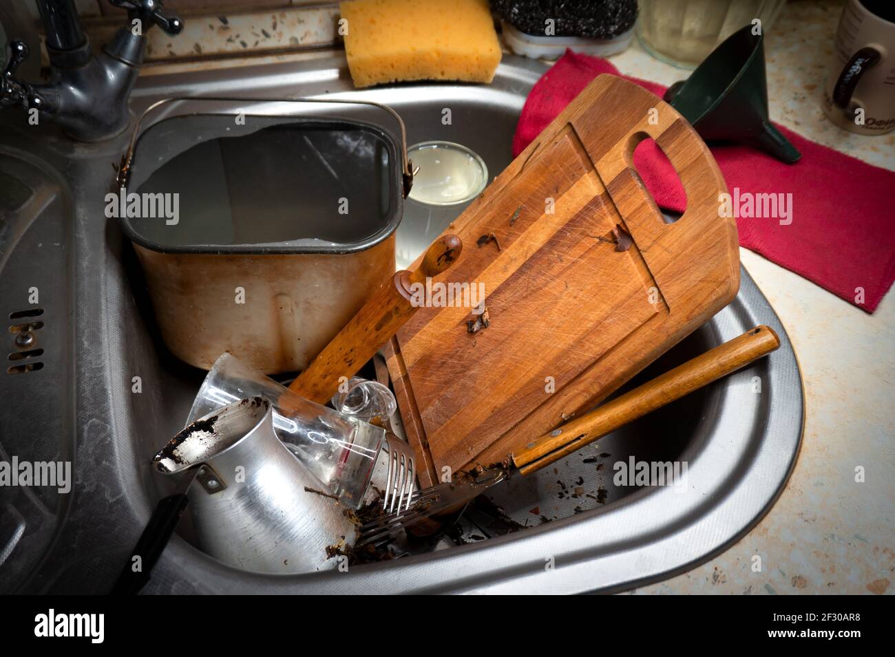 Viel schmutziges Geschirr und ein Durcheinander in der Spülbecken in der Küche Stockfoto