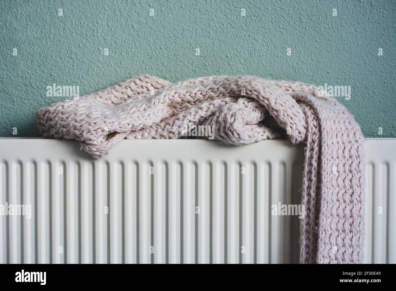 Weich gestrickter rosa Schal trocknet auf einem Heizkörper nach dem Nässen. Stockfoto