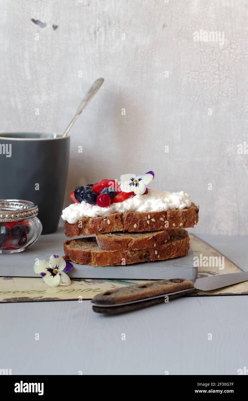 Getreidebrot mit Frischkäse und Sommerbeersalat Stockfoto