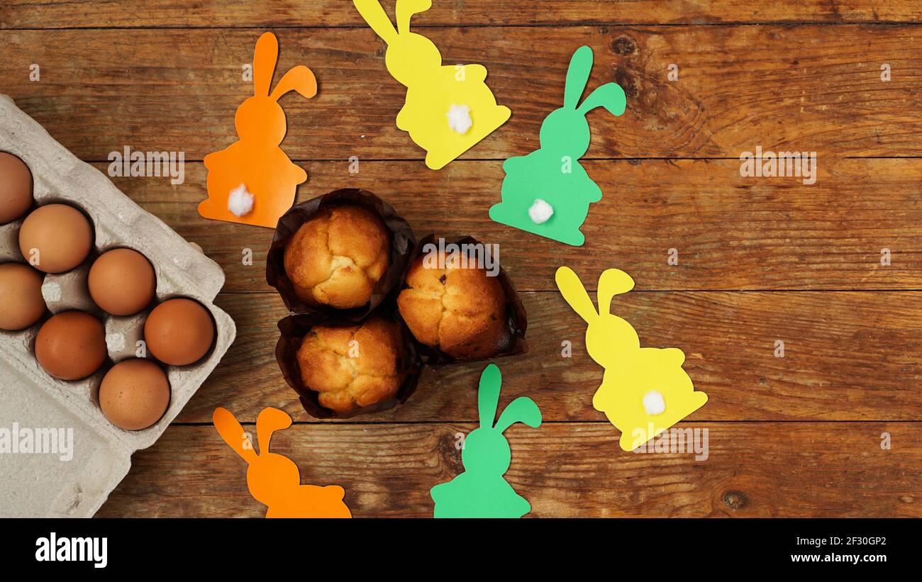 Hausgemachte Muffins mit Papierkaninchen. Muffin und Eier auf einem Holzhintergrund Stockfoto