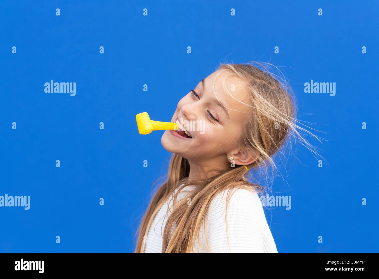 Studio Portrait Eines Glucklichen Lachelnden Jungen Madchen Geburtstag Feiern Halten Party Geblase Im Mund Spass Isoliert Auf Blau Hochwertige Fotos Stockfotografie Alamy