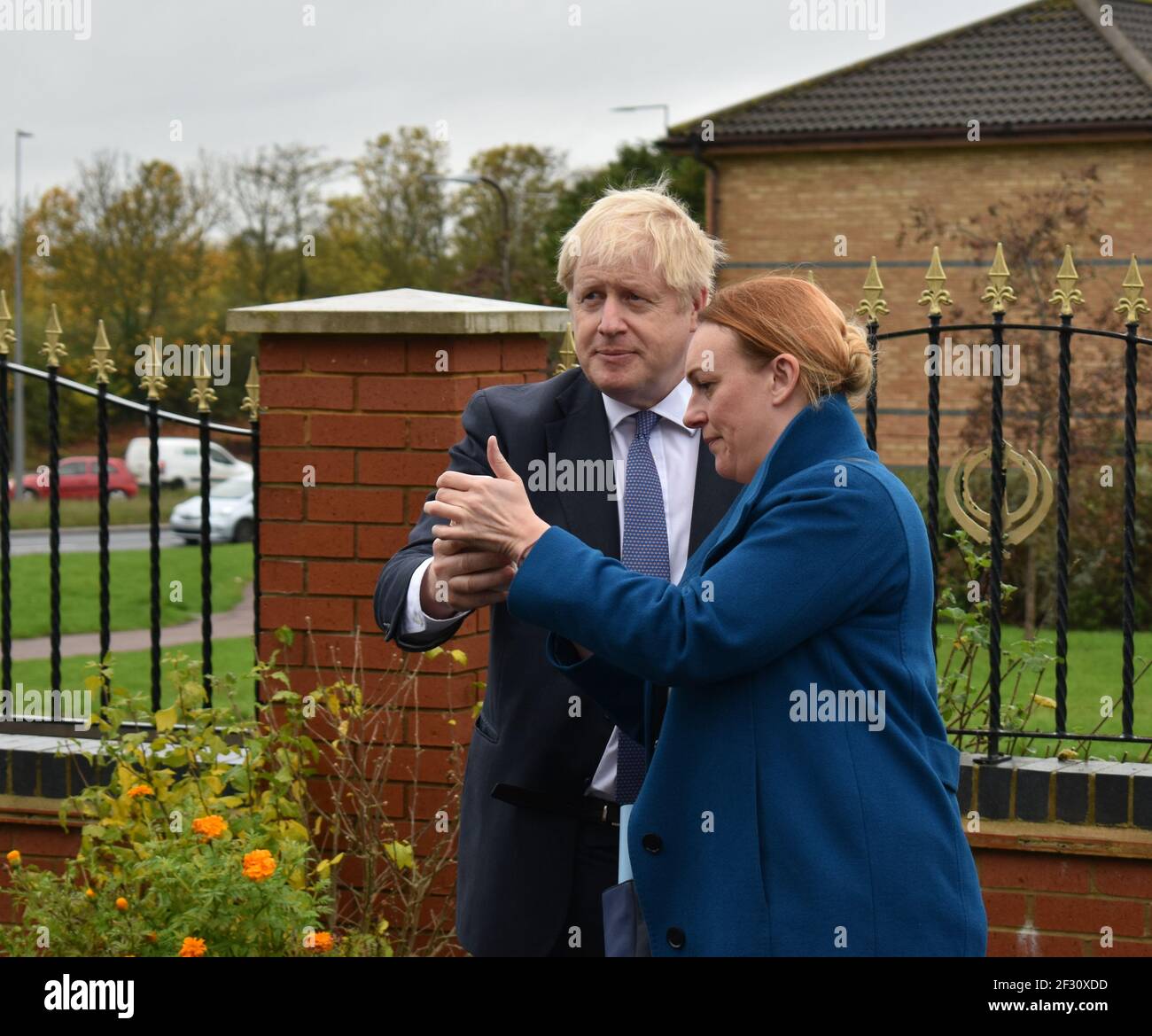 Shelley Williams-Walker und Boris Johnson in Milton Keynes im Oktober 2019, als er Premier war und sie die Leiterin der Operationen war. Mr. Johnson hält sein Handy in der Hand. Stockfoto