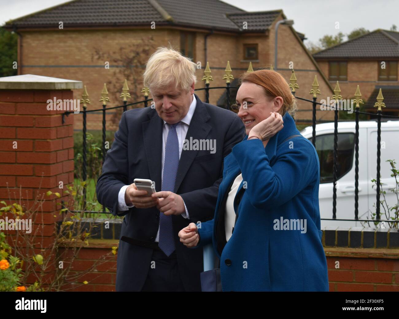 Shelley Williams-Walker und Boris Johnson in Milton Keynes im Oktober 2019, als er Premier war und sie die Leiterin der Operationen war. Mr. Johnson hält sein Handy in der Hand. Stockfoto