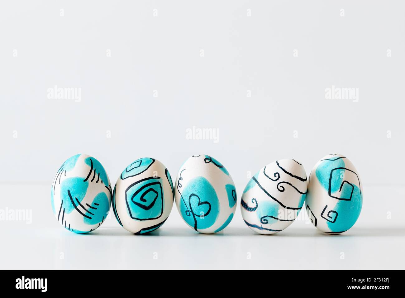 Kreative trendige bemalte ostereier auf weißem Hintergrund. Osterideen. Stockfoto