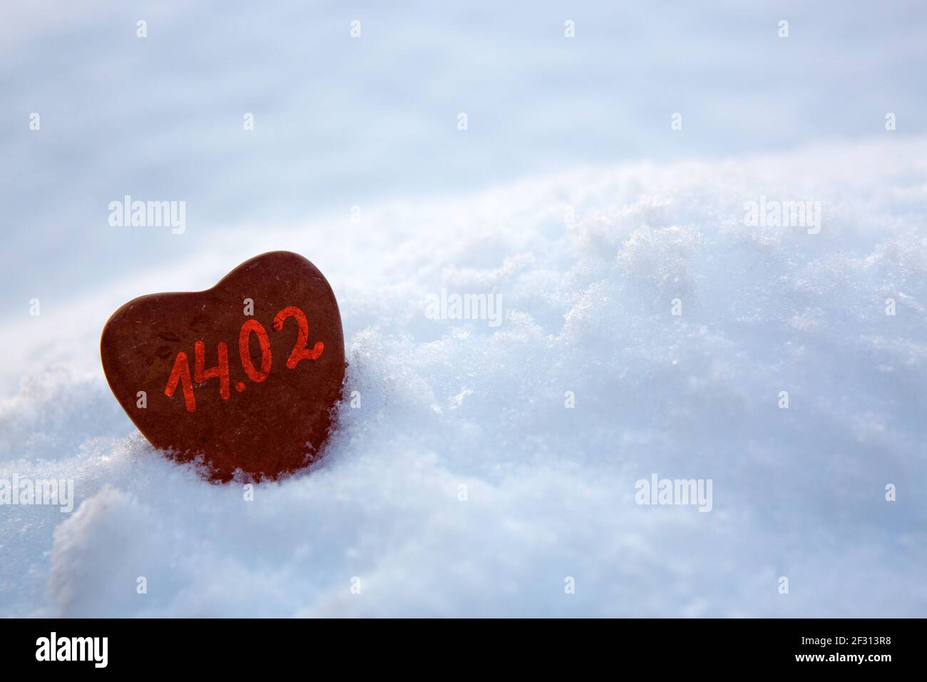 Herz aus rotem Stein im weißen Schnee. Valentinskarte. Stockfoto