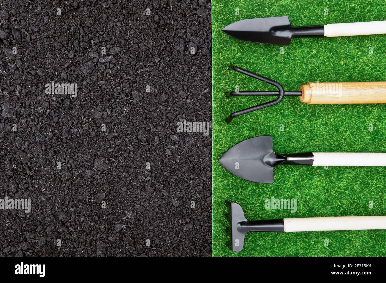 Gartenhandschaufel, Rechen, Transplanter und Grubber auf einem kontrastierenden Gras- und Bodenhintergrund. Gartenbanner Konzept. Stockfoto